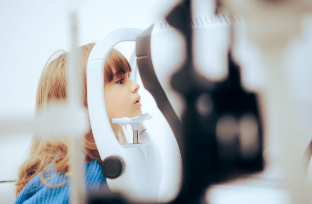 A young girl having he eyes assessed for myopia at the optometrist.