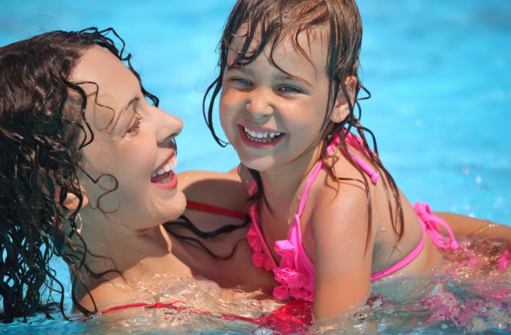 A woman and her young child swimming in a pool.