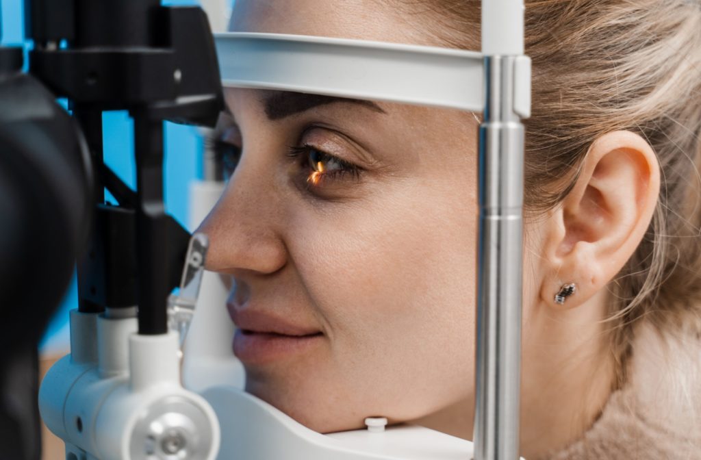 Close-up of a woman undergoing a slit-lamp examination during a comprehensive eye exam.