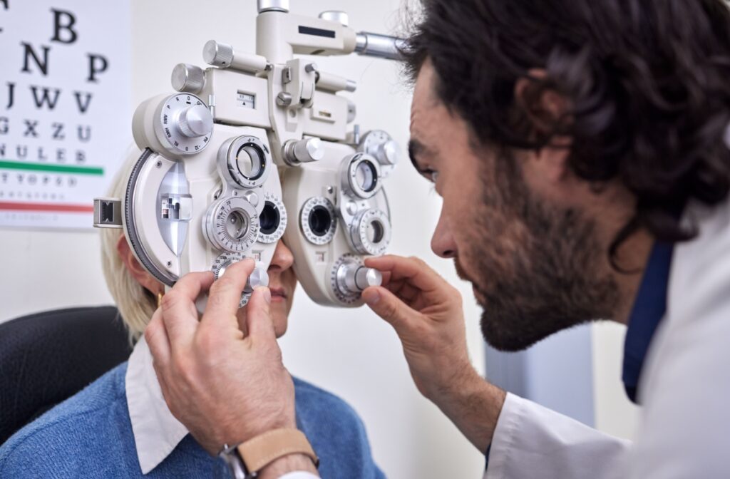 An eye doctor adjusting a phoropter during a comprehensive eye exam.